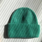 Teal green ribbed knit beanie hat with folded cuff, made from soft fuzzy wool-blend fabric