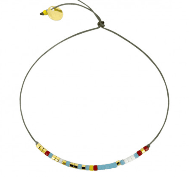 Adjustable cord bracelet with colorful beaded pattern in yellow, red, blue, white and black with small gold charm disc