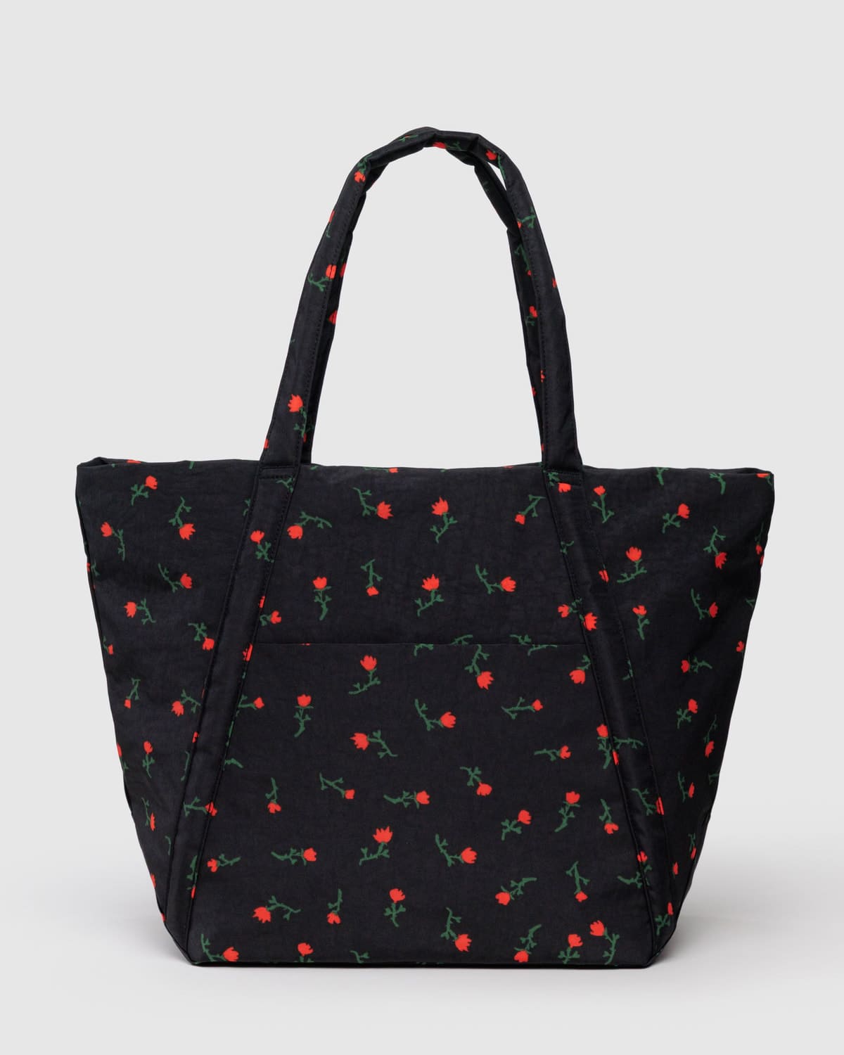 Black quilted tote bag with red rose and green stem pattern, featuring dual handles and front slip pocket