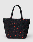 Black quilted tote bag with red rose and green stem pattern, featuring dual handles and front slip pocket