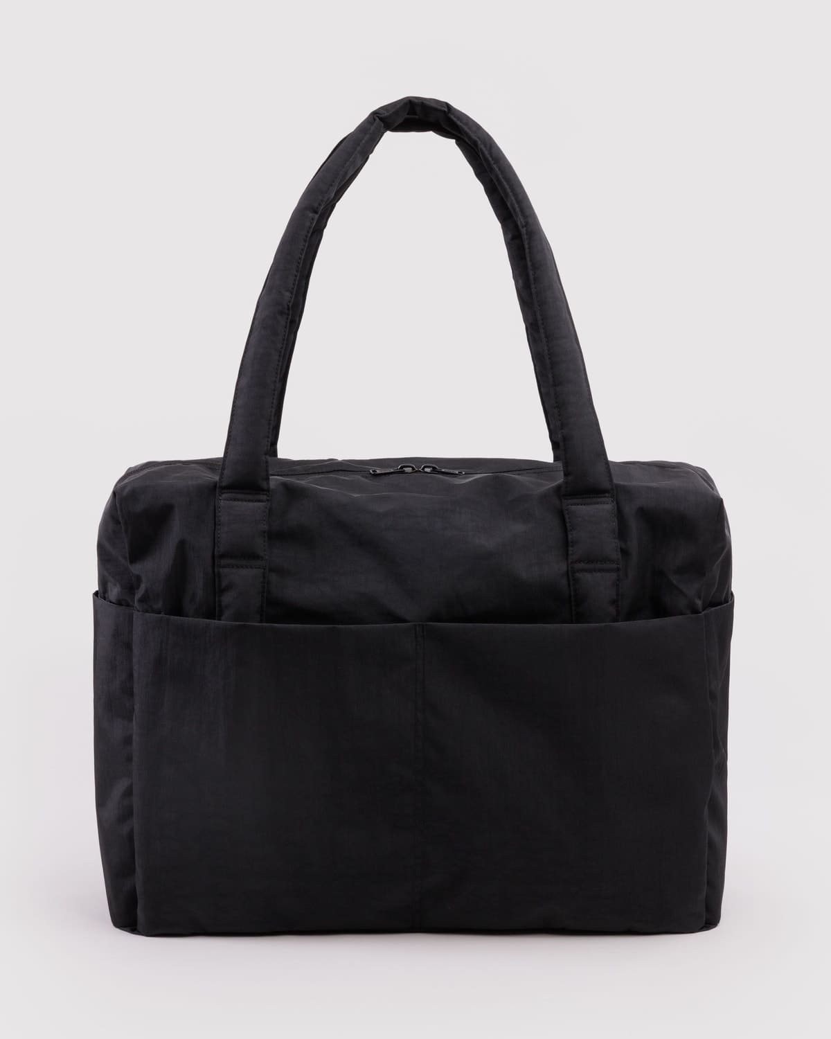 Black quilted nylon tote bag with padded handles and exterior slip pockets on a light gray background