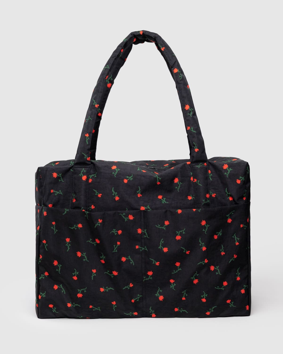Black quilted tote bag with small red floral print pattern and padded handles
