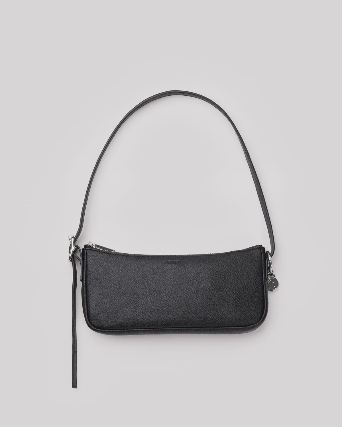 Black pebbled leather shoulder bag with zip closure, adjustable strap, and silver hardware charm detail