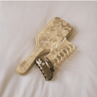 Beige marbled resin hair claw clip with abstract swirl pattern and gold-tone metal clasp on white background