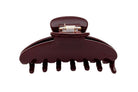 Brown plastic hair claw clip with metal hinge mechanism, featuring curved design with seven teeth for securing hair