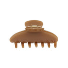 Large brown translucent hair claw clip with rounded top and seven teeth, featuring metal spring clasp mechanism