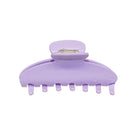 Purple plastic hair claw clip with seven teeth and metal spring clasp mechanism, shown from side angle on white background