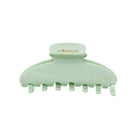 Mint green plastic hair claw clip with curved design and metal clasp mechanism, featuring seven teeth for secure hold