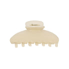 Cream-colored plastic hair claw clip with rounded shape and metal spring clasp closure, featuring seven teeth along the bottom edge