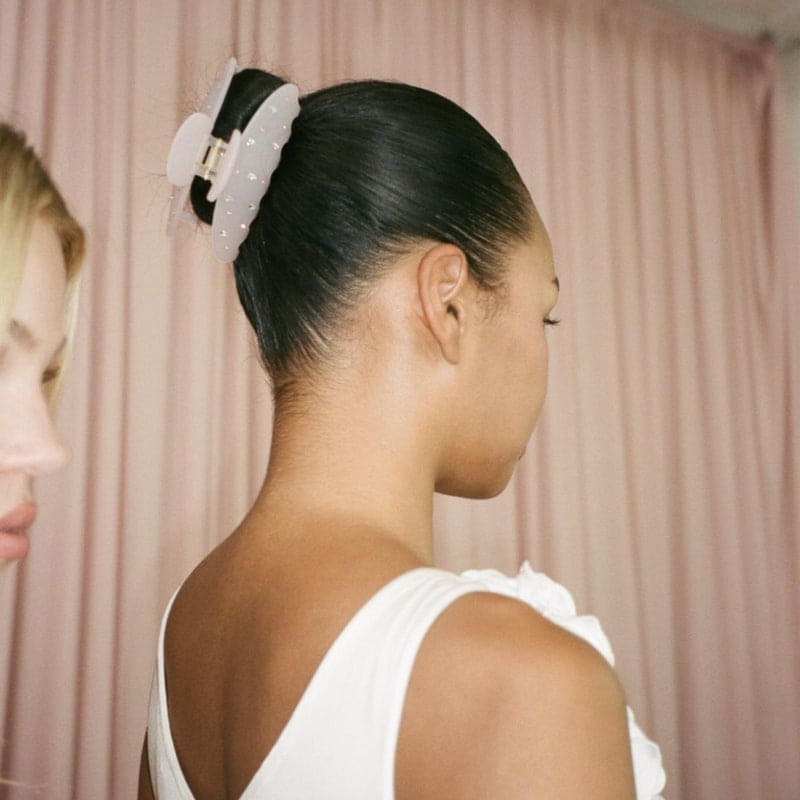 White tulle scrunchie with black velvet bow accent and gold clasp detail for hair styling