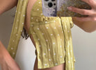 Yellow polka dot wrap top with tie waist detail, lightweight fabric, short sleeves, mirror selfie showing fit and style