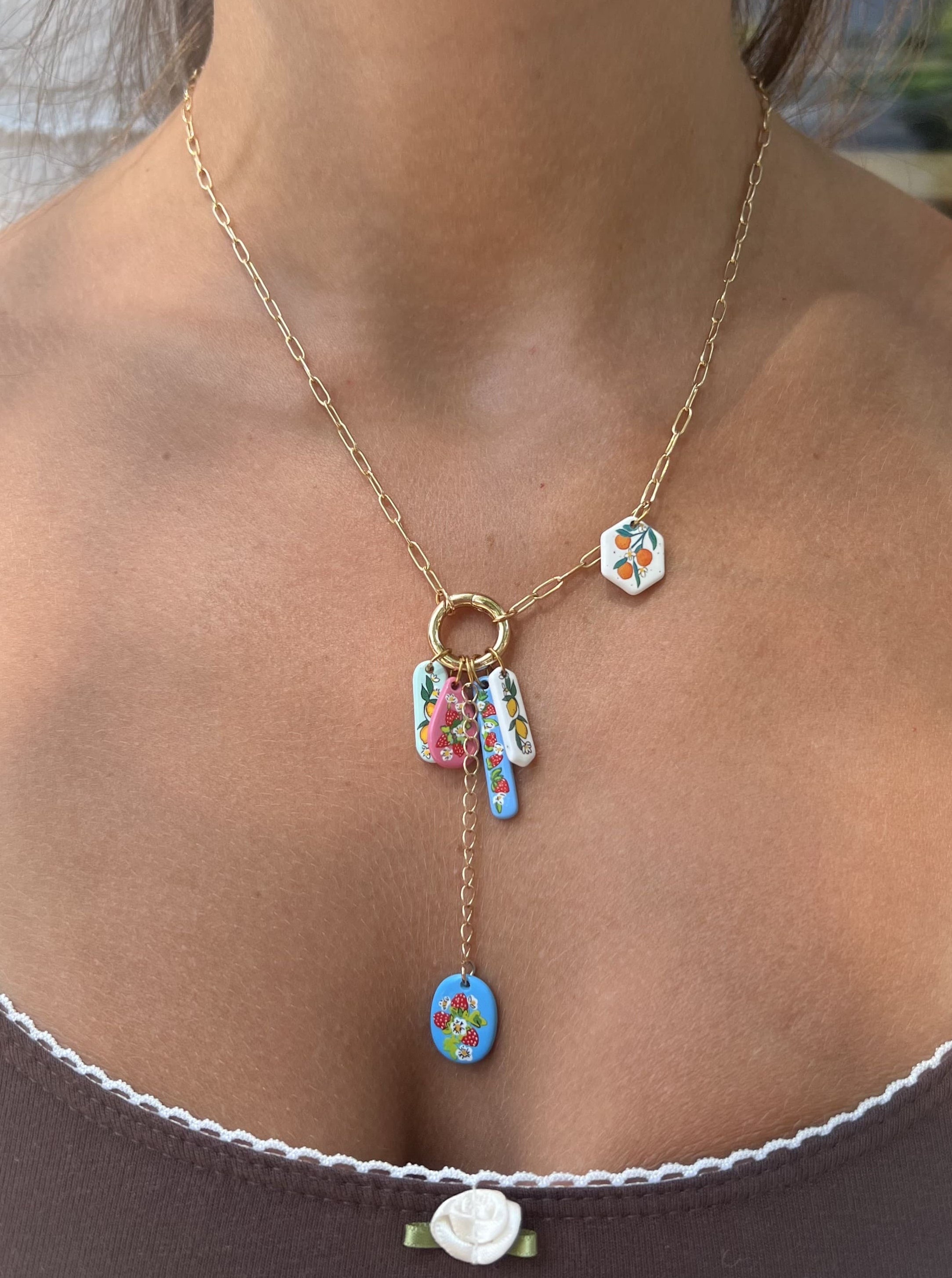Necklace with colorful pendants worn by a person