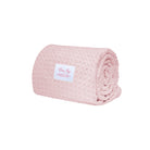 Rolled pink blanket with a label on a white background