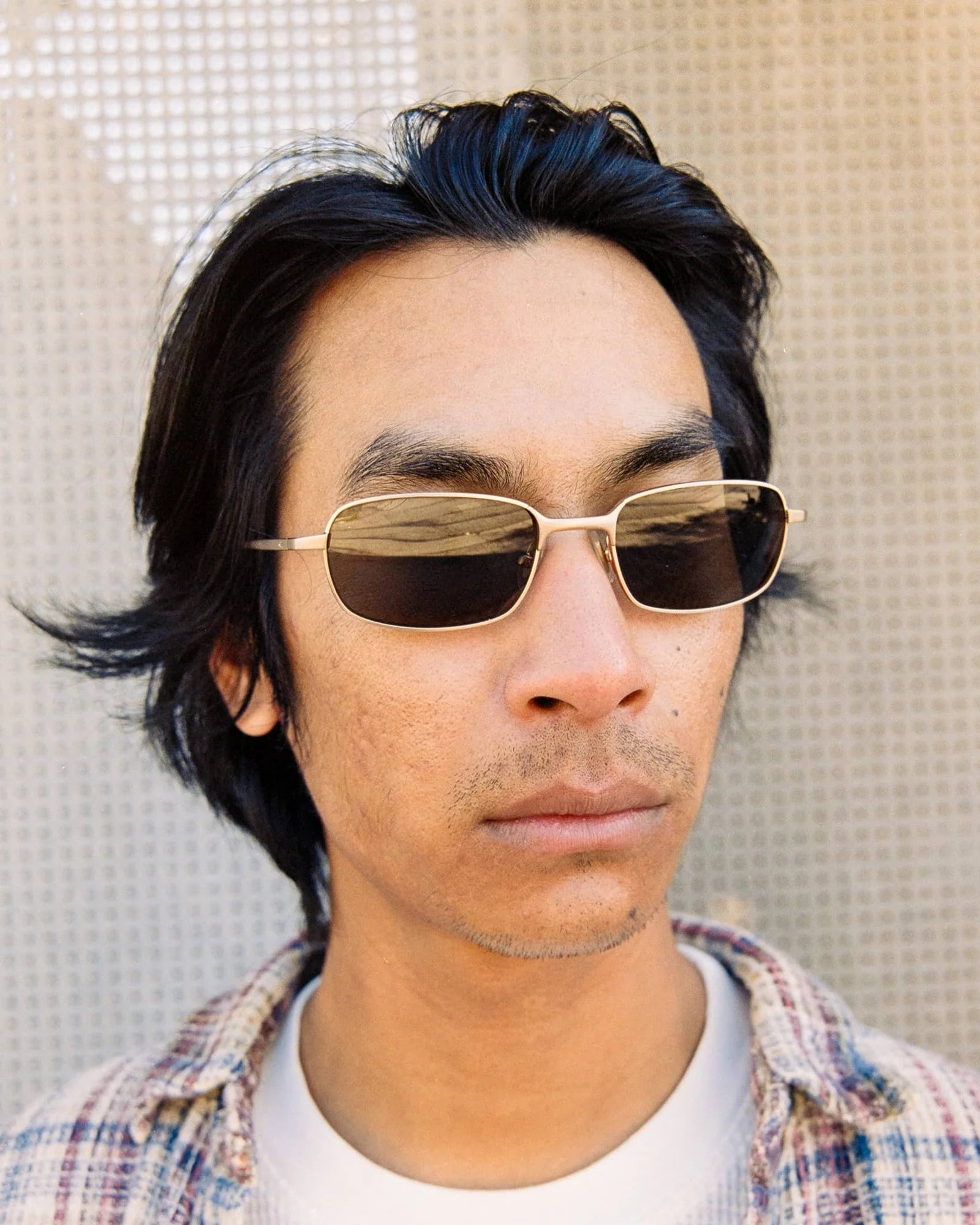 Man wearing sunglasses with a neutral background
