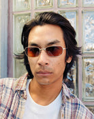 Person wearing sunglasses with a textured wall background