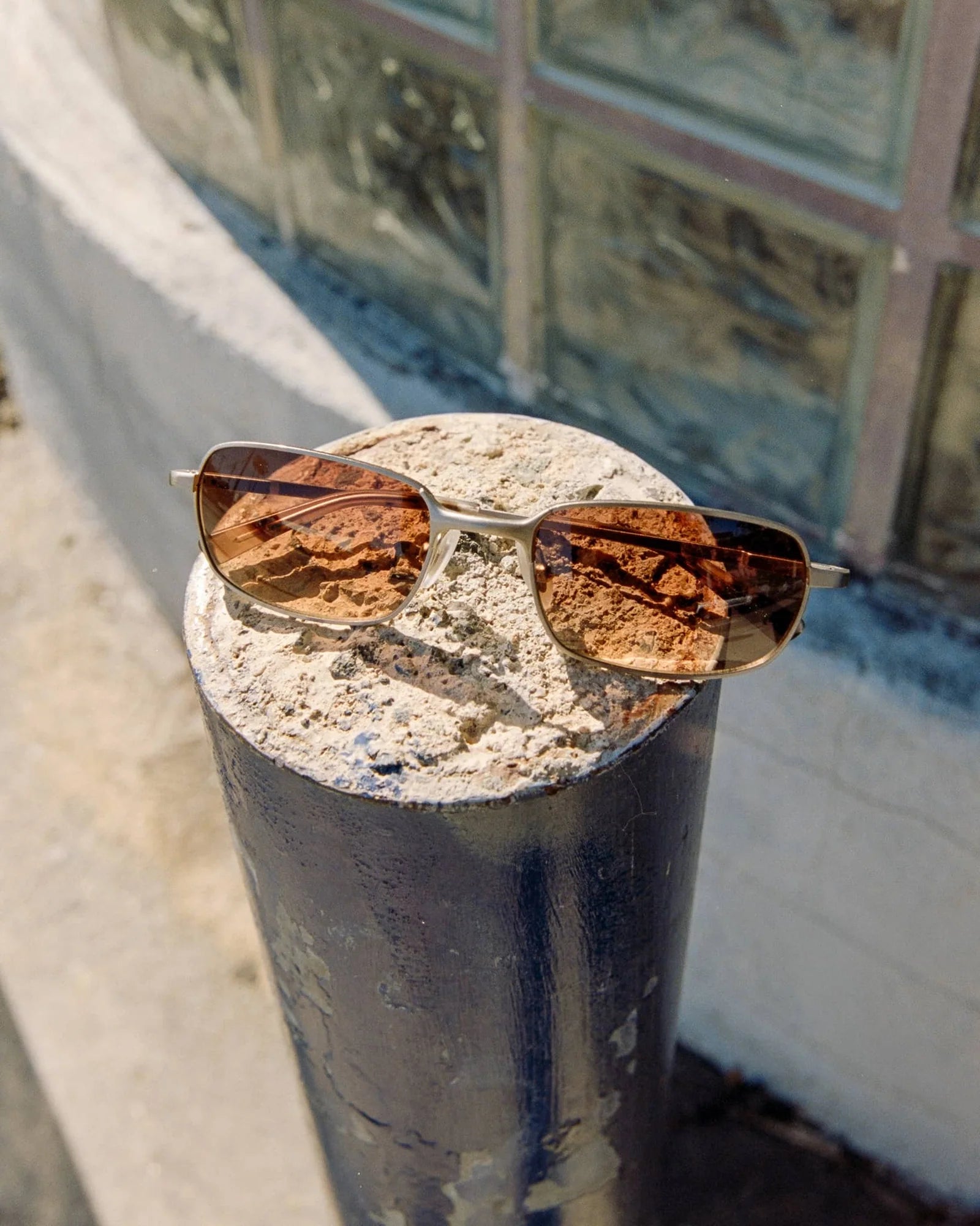 Brown sunglasses on a concrete surface with a blurred background