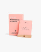 Pink affirmation card deck with wooden stand displaying "I radiate unconditional love" card from Mindful Affirmations Love & Relationships set