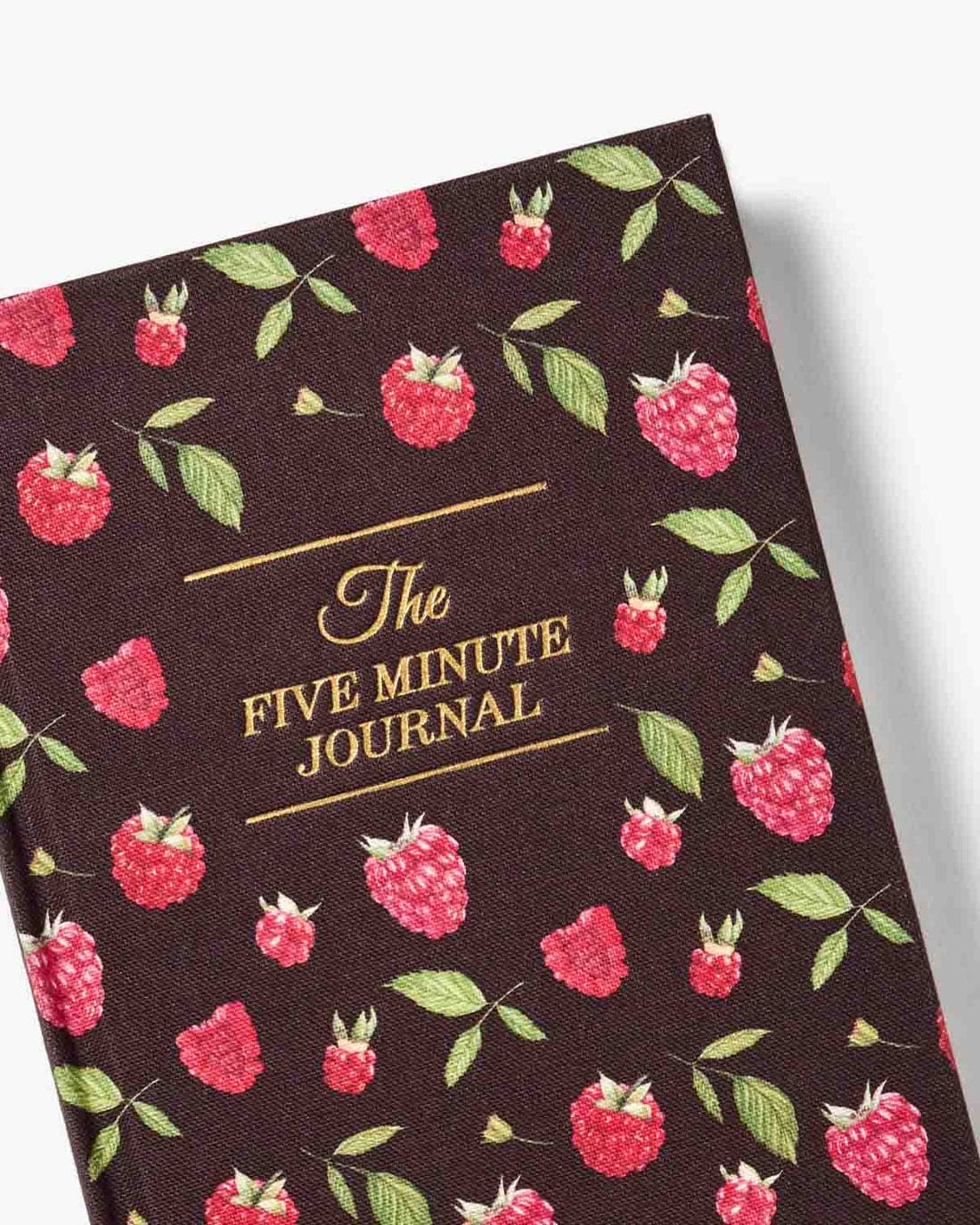 Dark brown fabric journal with pink raspberry and green leaf pattern, gold foil text reading "The Five Minute Journal"