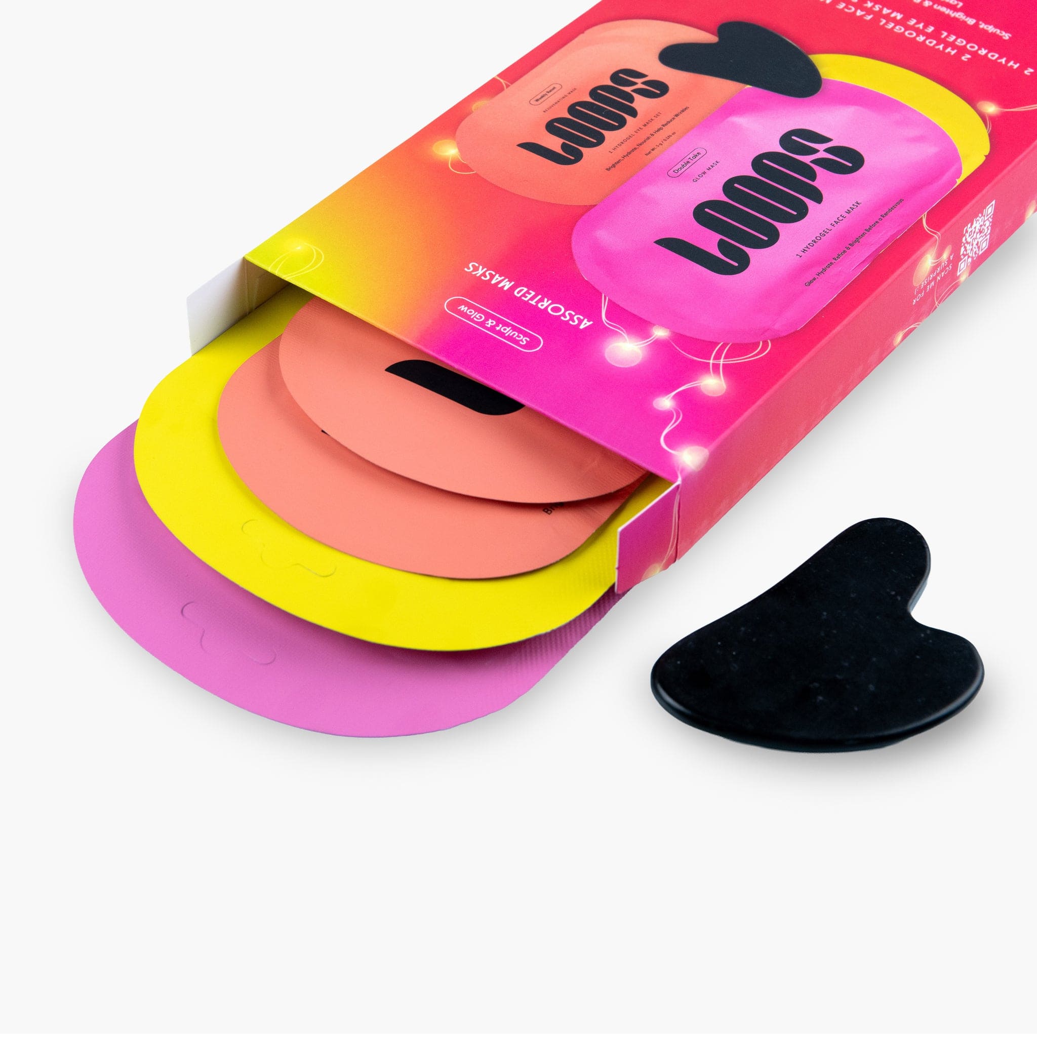 Colorful face mask set with pink, yellow, and coral circular masks sliding out of gradient packaging, plus black gua sha tool