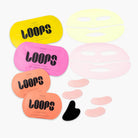 Loops hydrogel face and eye mask set with yellow, pink, and orange packaging, plus light yellow and pink sheet masks and gua sha tool