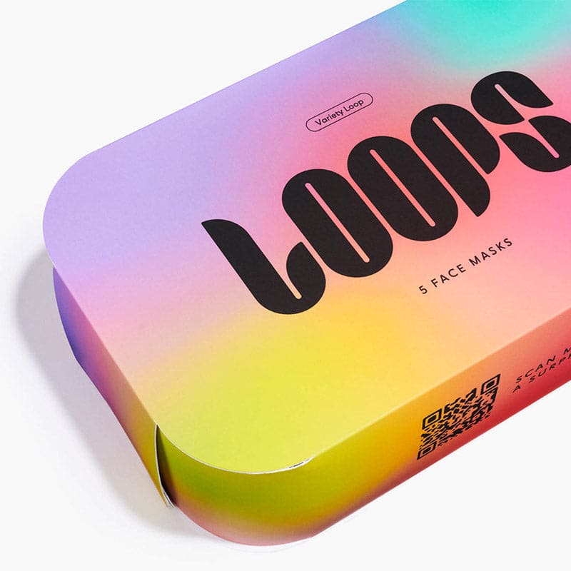 Colorful gradient face mask box with rainbow ombre design from purple to yellow, featuring bold black typography and rounded edges