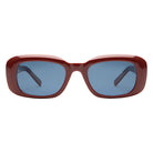 Sunglasses with a red frame and blue lenses on a white background
