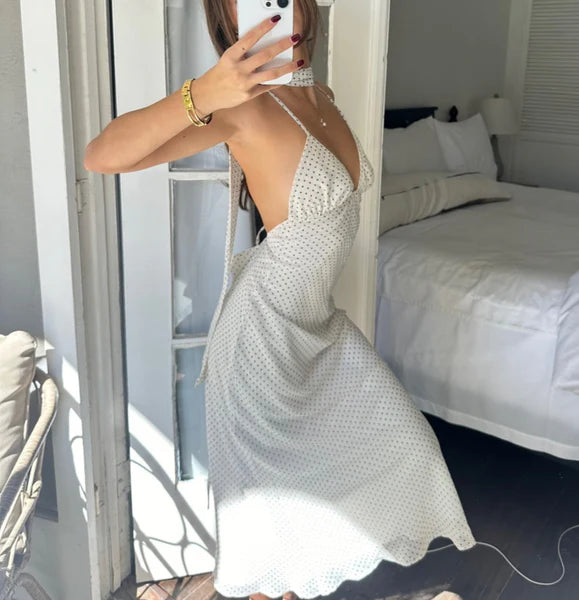 White polka dot midi dress with halter neck, plunging neckline, and A-line silhouette modeled in bedroom mirror selfie