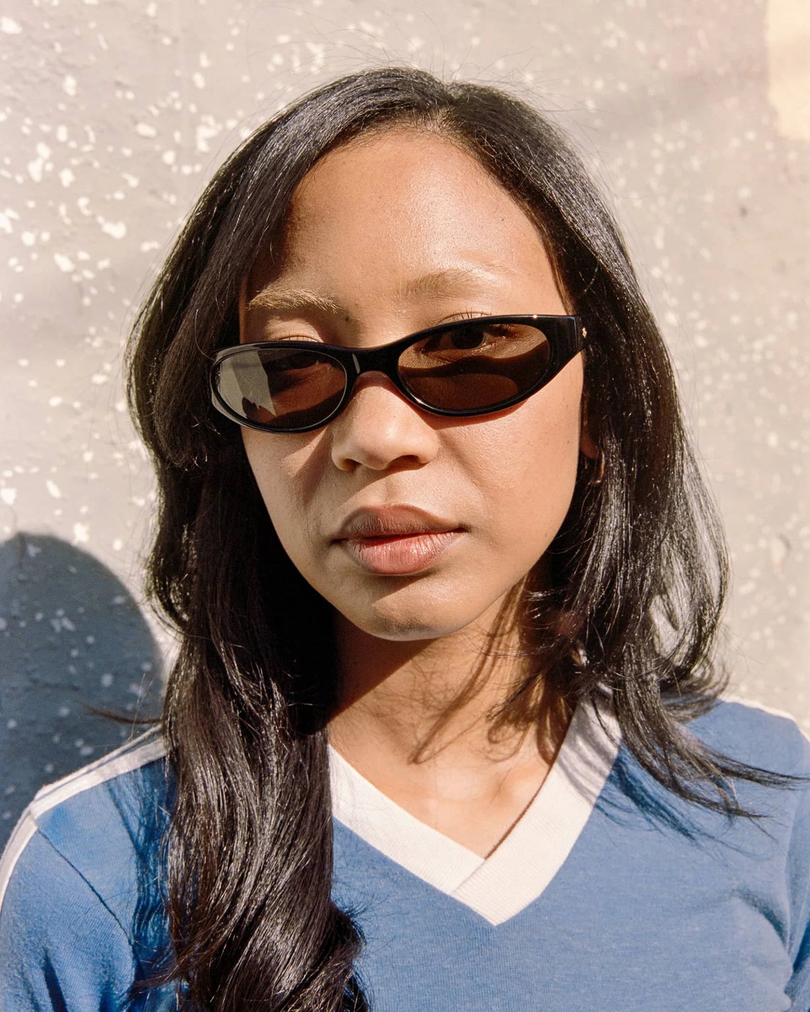 Woman wearing sunglasses with a neutral background