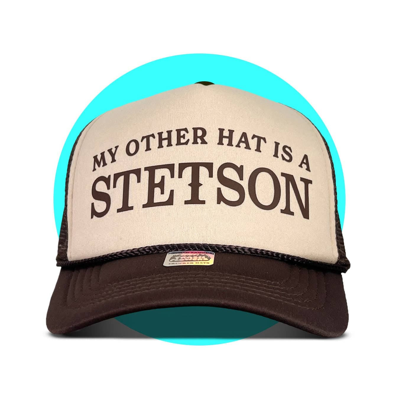 Brown and tan trucker hat with "MY OTHER HAT IS A STETSON" text on front foam panel and mesh back