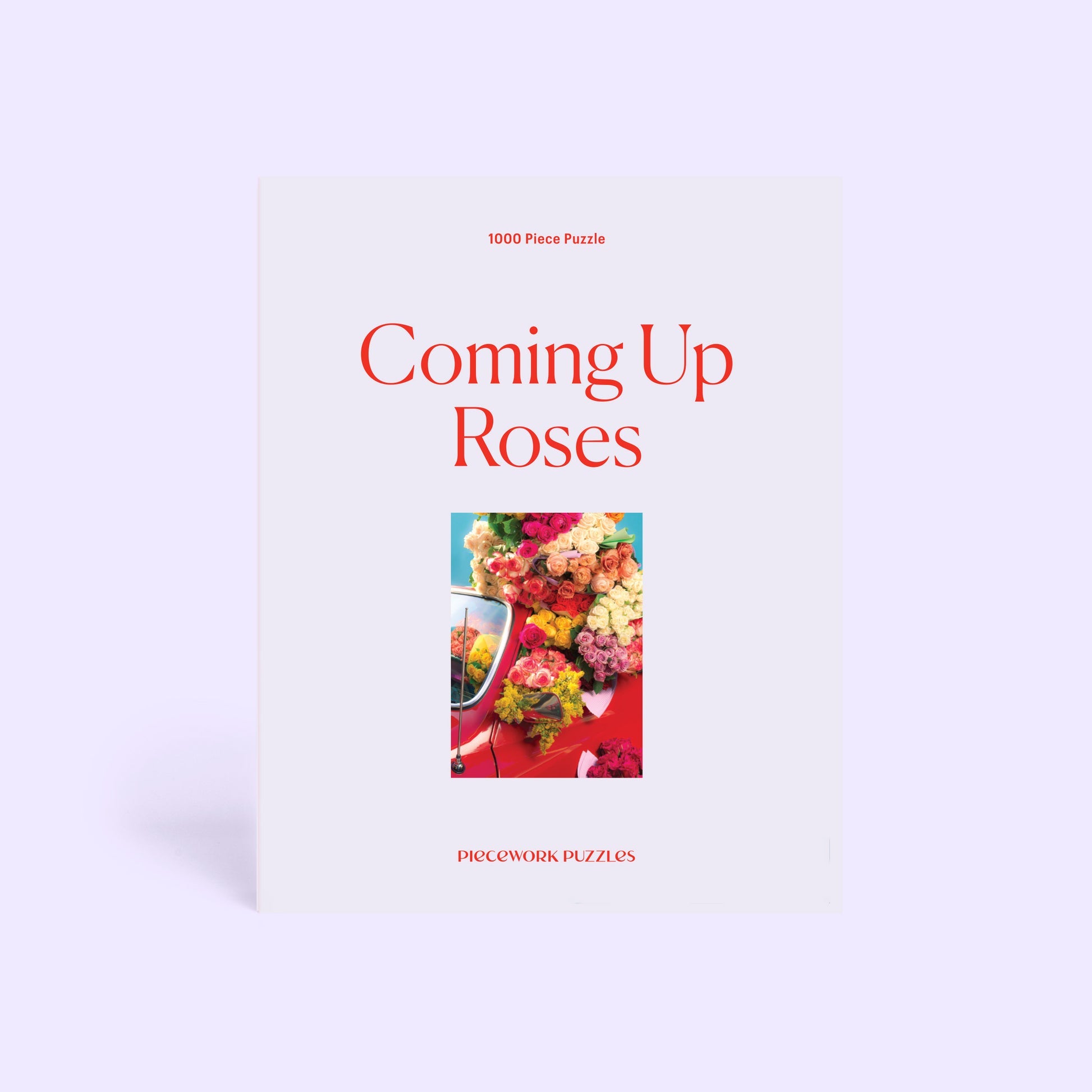 Jigsaw puzzle box featuring colorful roses and flowers with title "Coming Up Roses" in red text, 1000 pieces by Piecework Puzzles