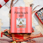 Jigsaw puzzle box featuring Palm Beach Idyll design with coral striped packaging and beach scene photo by Slim Aarons