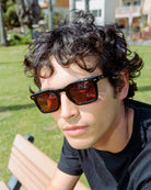 Person wearing sunglasses with a blurred outdoor background