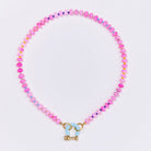 Pink beaded necklace with small metallic spacer beads and blue enamel toggle clasp on white background