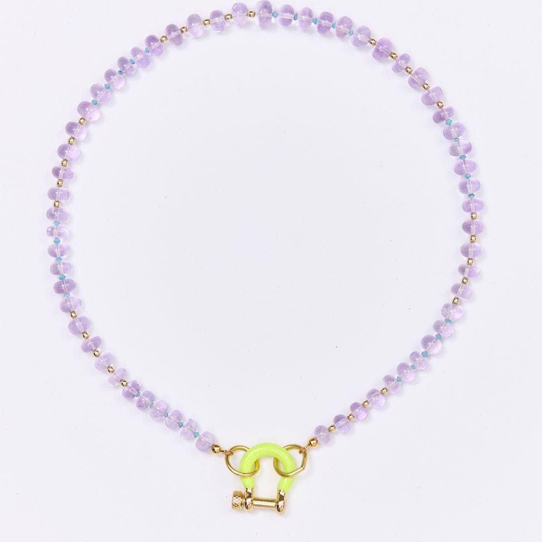 Beaded necklace with purple glass beads, gold spacers, and neon yellow toggle clasp on white background