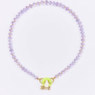 Beaded necklace with purple glass beads, gold spacers, and neon yellow toggle clasp on white background