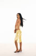 Yellow sequined backless halter dress with open back and side slit, knee-length