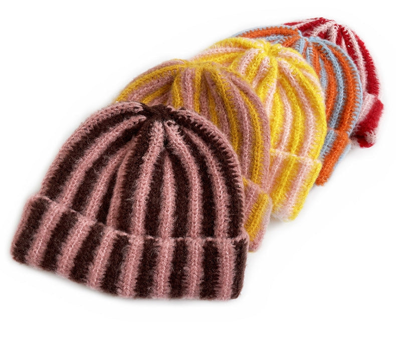 Striped ribbed knit beanies in multiple colorways including pink/brown, yellow, orange/blue, and red, arranged in a row.