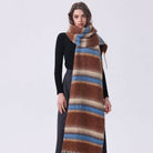 Oversized striped mohair scarf in brown, blue, and cream with fringe, draped around neck over black outfit.