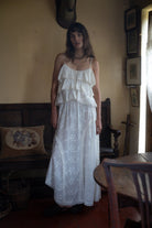 White tiered lace maxi dress with spaghetti straps and embroidered eyelet details on ruffled bodice and flowing skirt