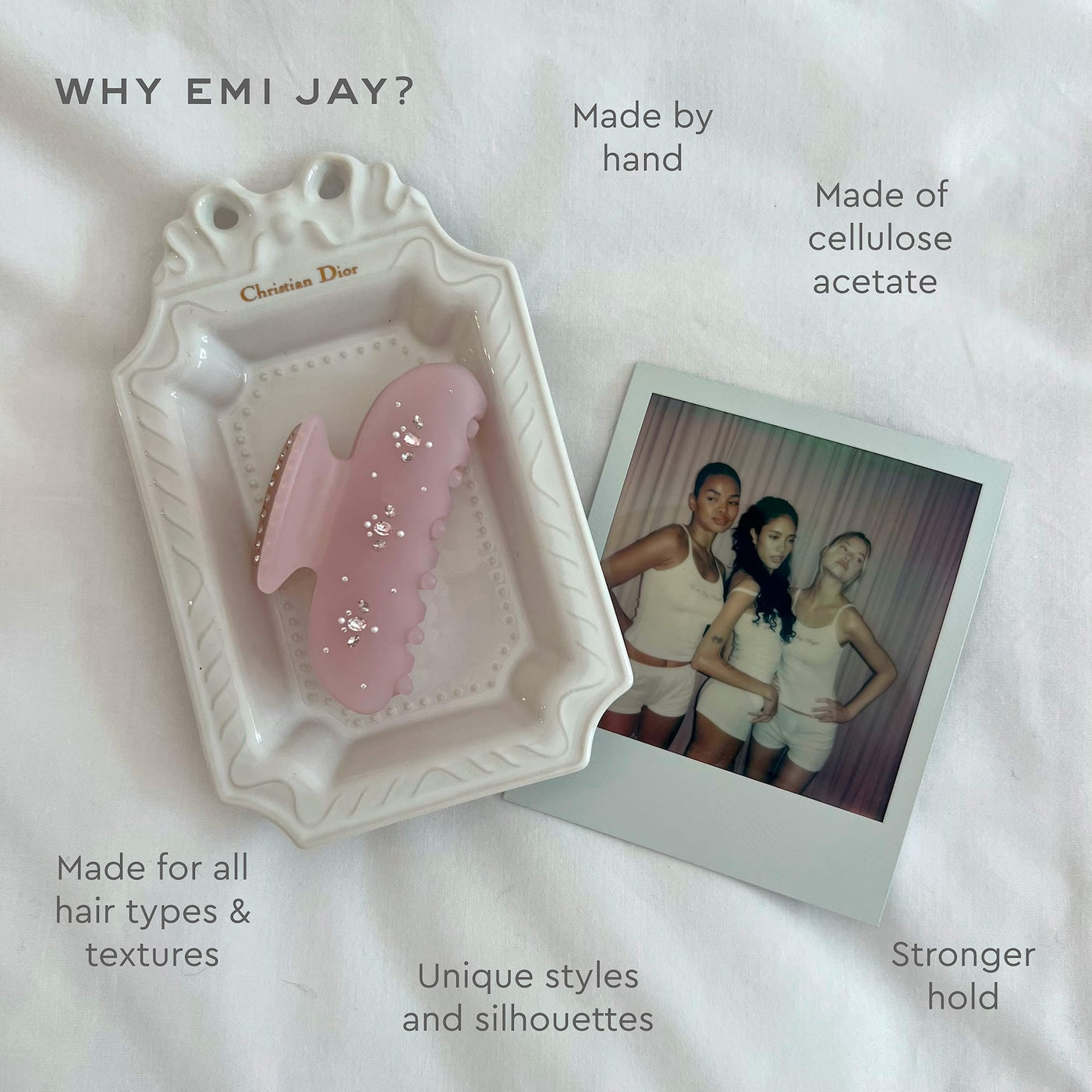 Pink cellulose acetate hair clip with wavy edges on white Christian Dior tray next to polaroid photo