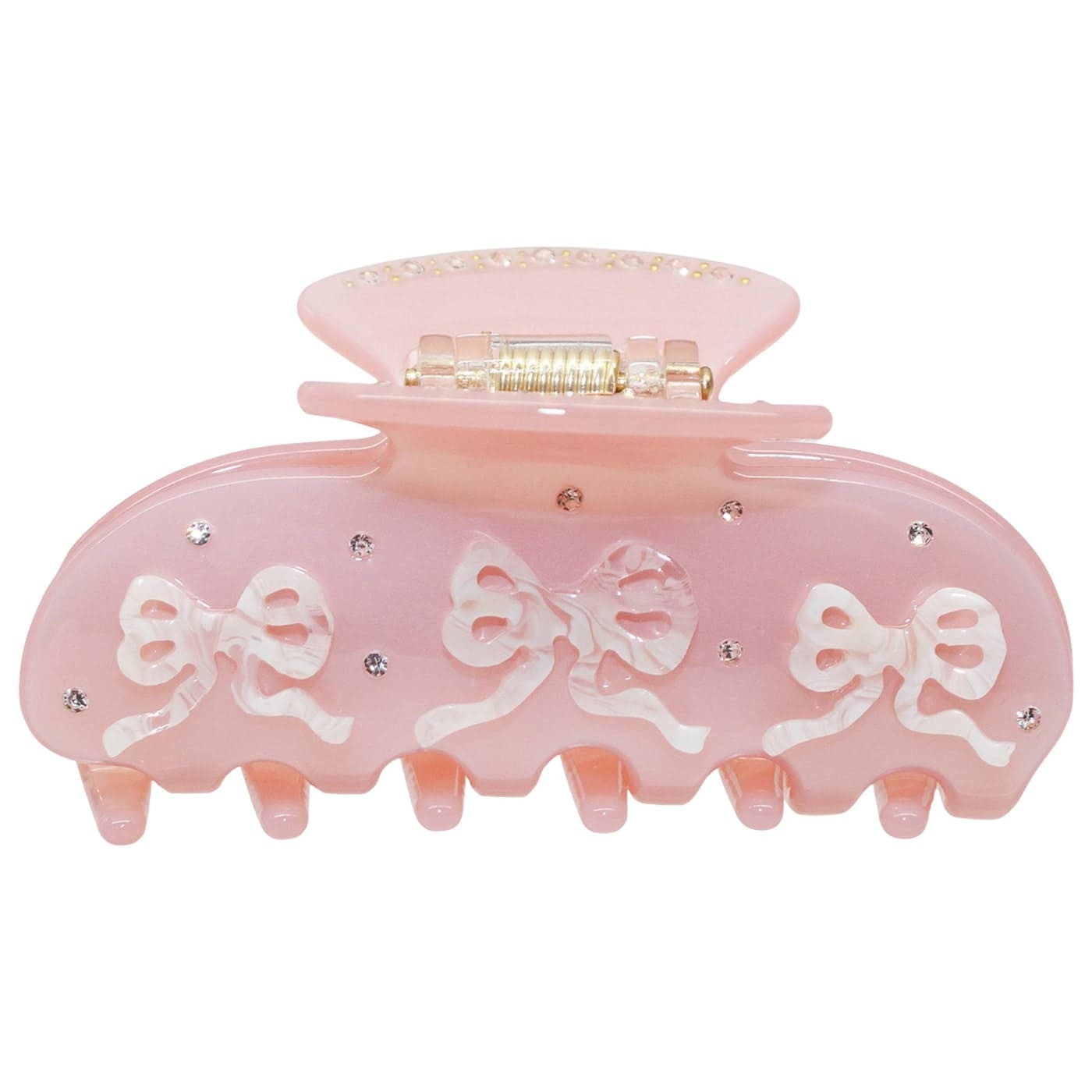 Pink plastic hair claw clip with white bow designs and clear rhinestone embellishments on a spring-loaded clasp