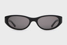 Black sunglasses with dark lenses on a light gray background