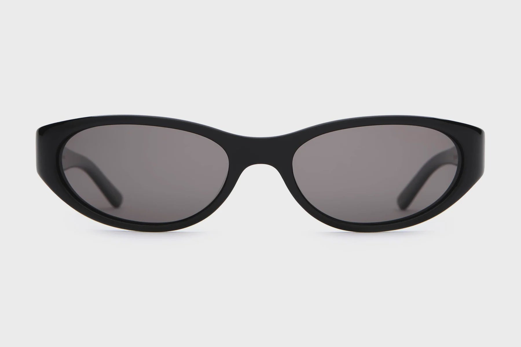 Black sunglasses with dark lenses on a light gray background