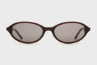 Oval brown tortoiseshell sunglasses with dark gray lenses and slim temples on white background